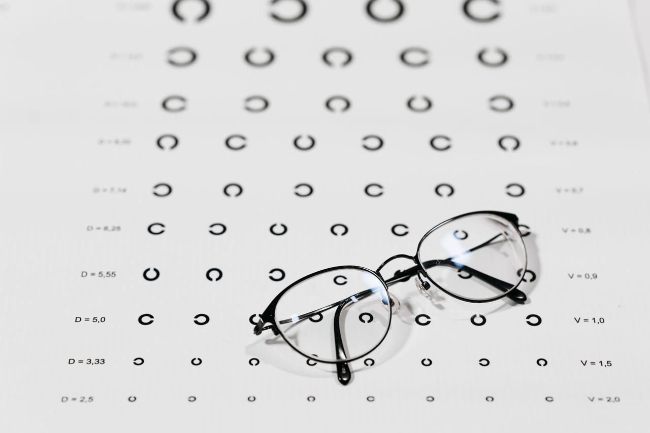 hero-img-01 Eyeglasses on a vision test chart, emphasizing eye care and optometry.